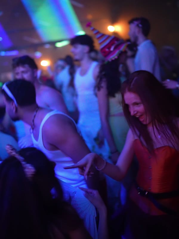 רחבה מלאה רוקדים באורות צבעוניים במסיבת פורים